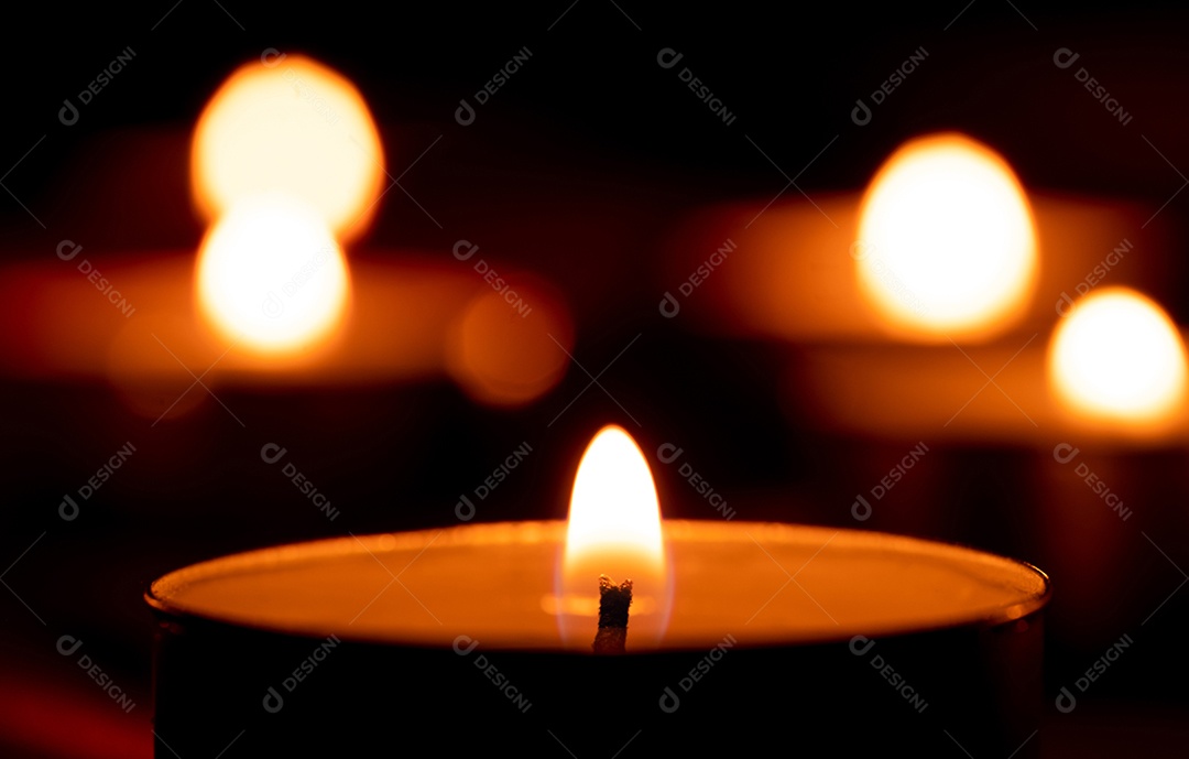 Luz de vela e fundo de tecido vermelho na escuridão