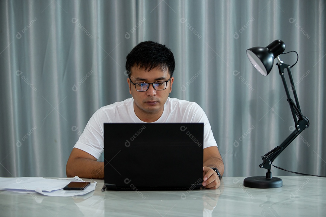 Homem jovem mexendo notebook sobre escritório