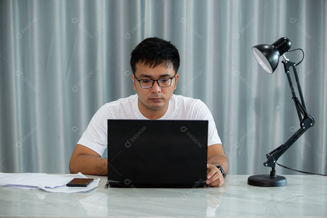 Homem jovem mexendo notebook sobre escritório