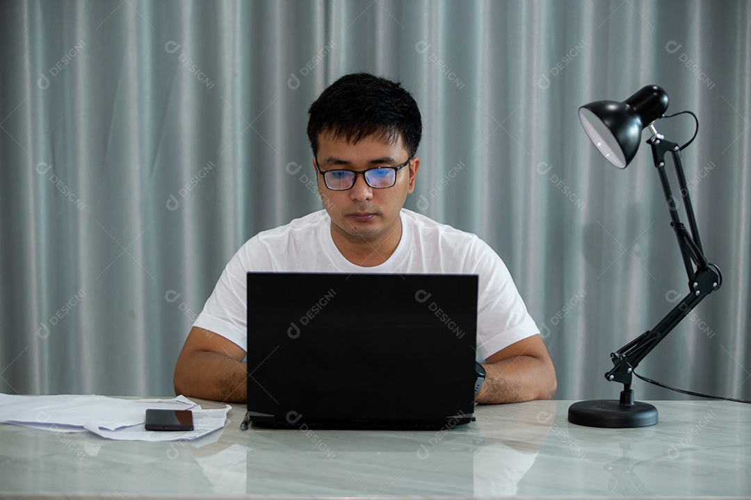 Homem jovem mexendo notebook sobre escritório