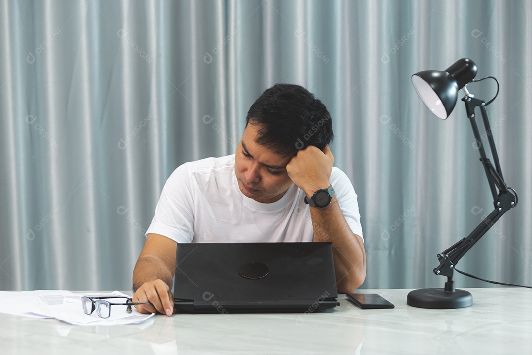 Homem jovem sobre escritório mexendo notebook
