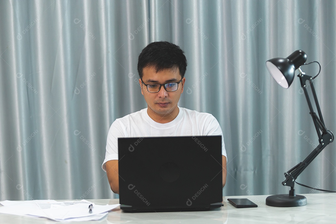 Homem jovem sobre escritório mexendo notebook