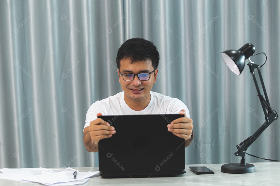 Homem jovem sobre escritório mexendo notebook