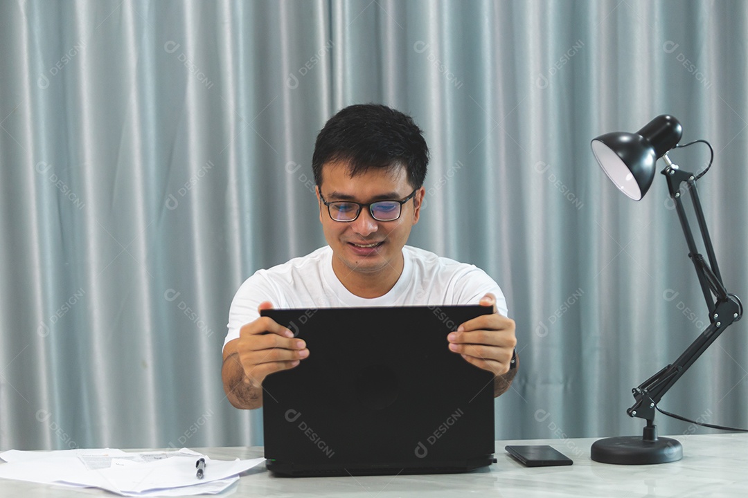 Homem jovem sobre escritório mexendo notebook
