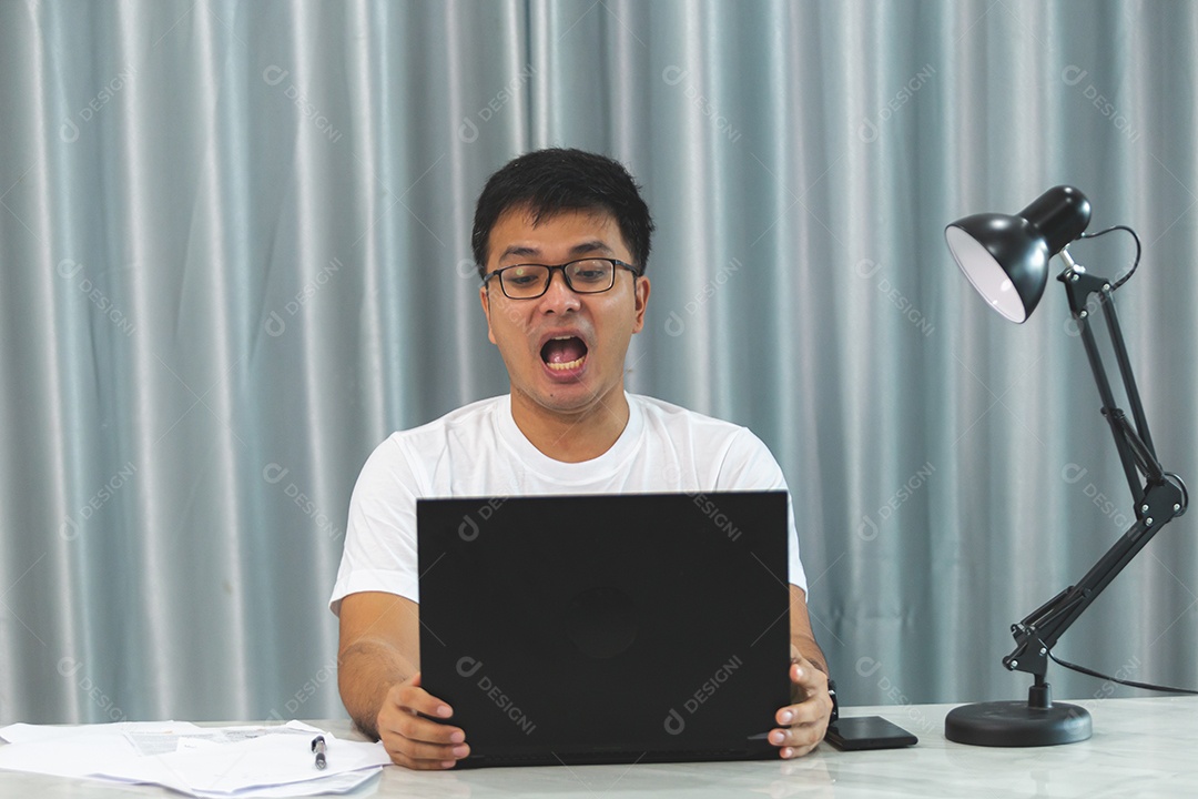 Homem jovem sobre escritório mexendo notebook