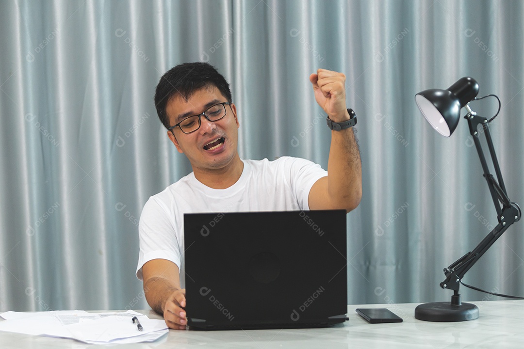 Homem jovem sobre escritório mexendo notebook