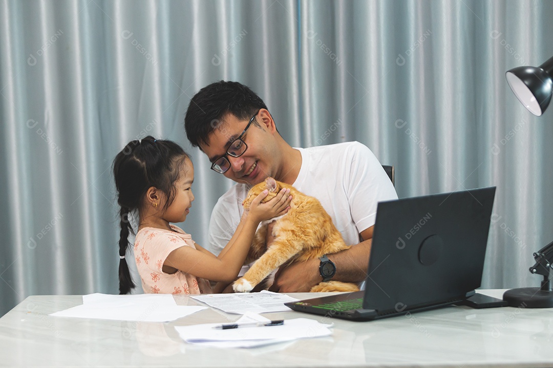 Pai e filha sobre uma mesa com seu gato de estimação