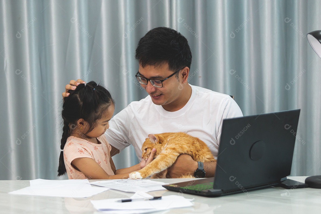 Pai e filha sobre uma mesa com seu gato de estimação