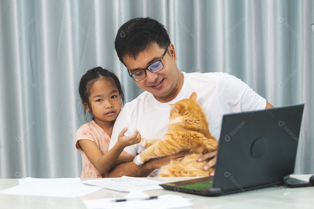 Pai e filha sobre uma mesa com seu gato de estimação