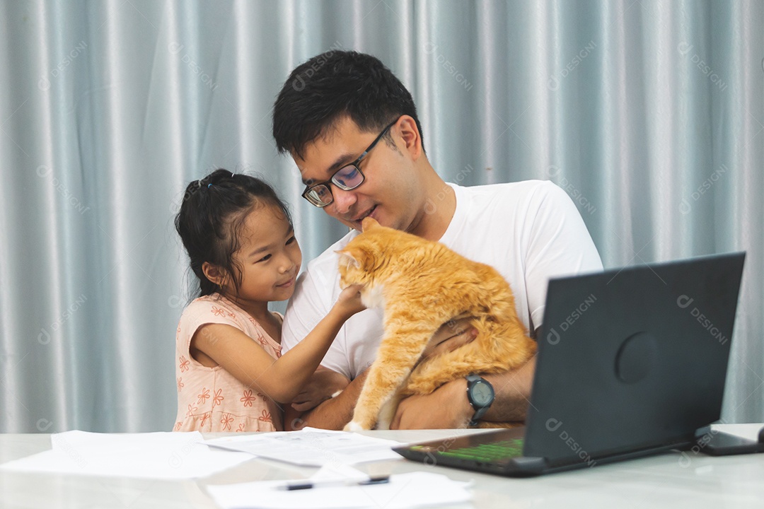 Pai e filha sobre uma mesa com seu gato de estimação