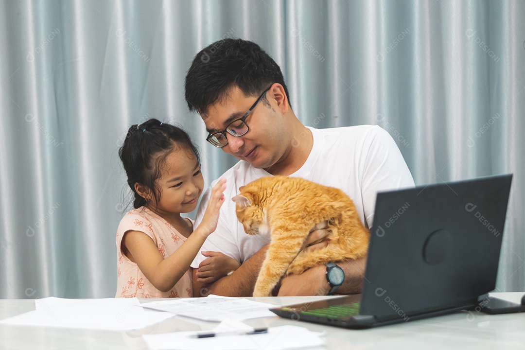 Pai e filha sobre uma mesa com seu gato de estimação