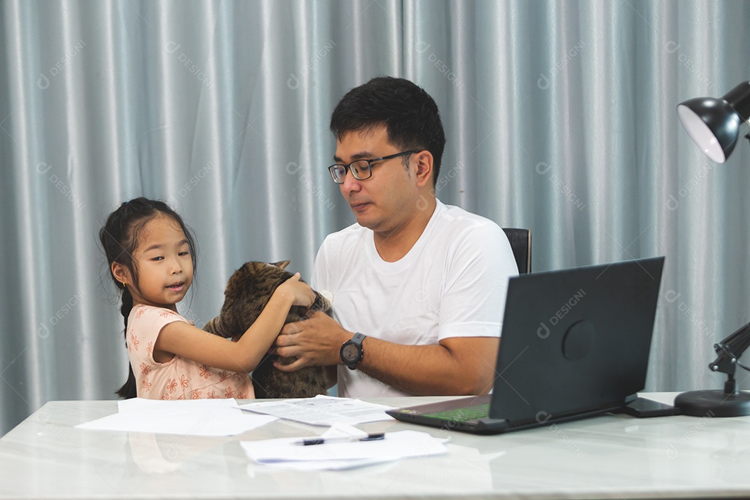 Pai e filha sobre uma mesa com seu gato de estimação