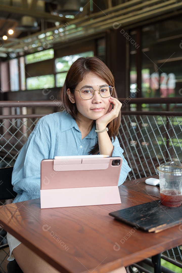 Mulher asiática feliz usando tablet de computador no café