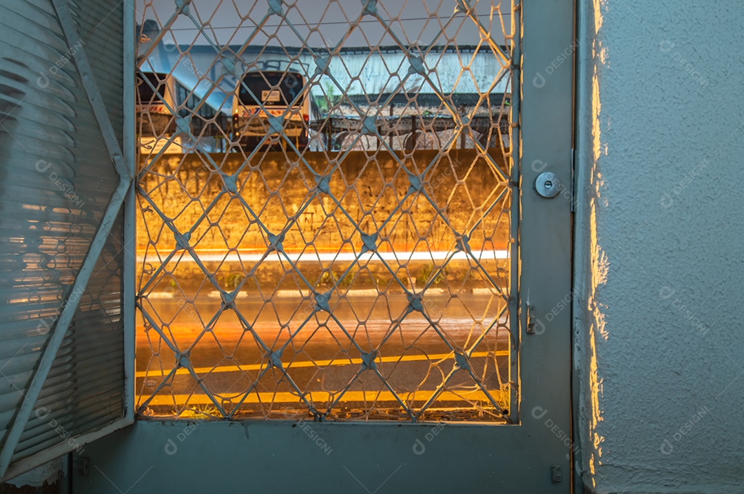 Porta aberta com iluminação pública no exterior, ambiente agradável