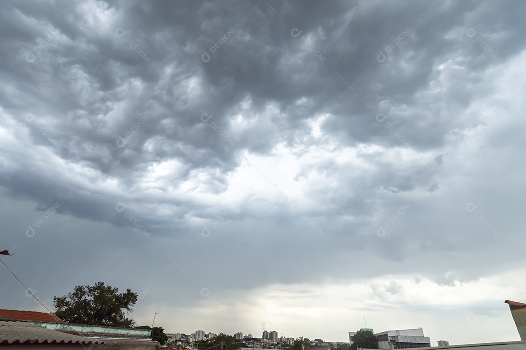 Céu nublado formando várias nuvens com cidade no horizonte.