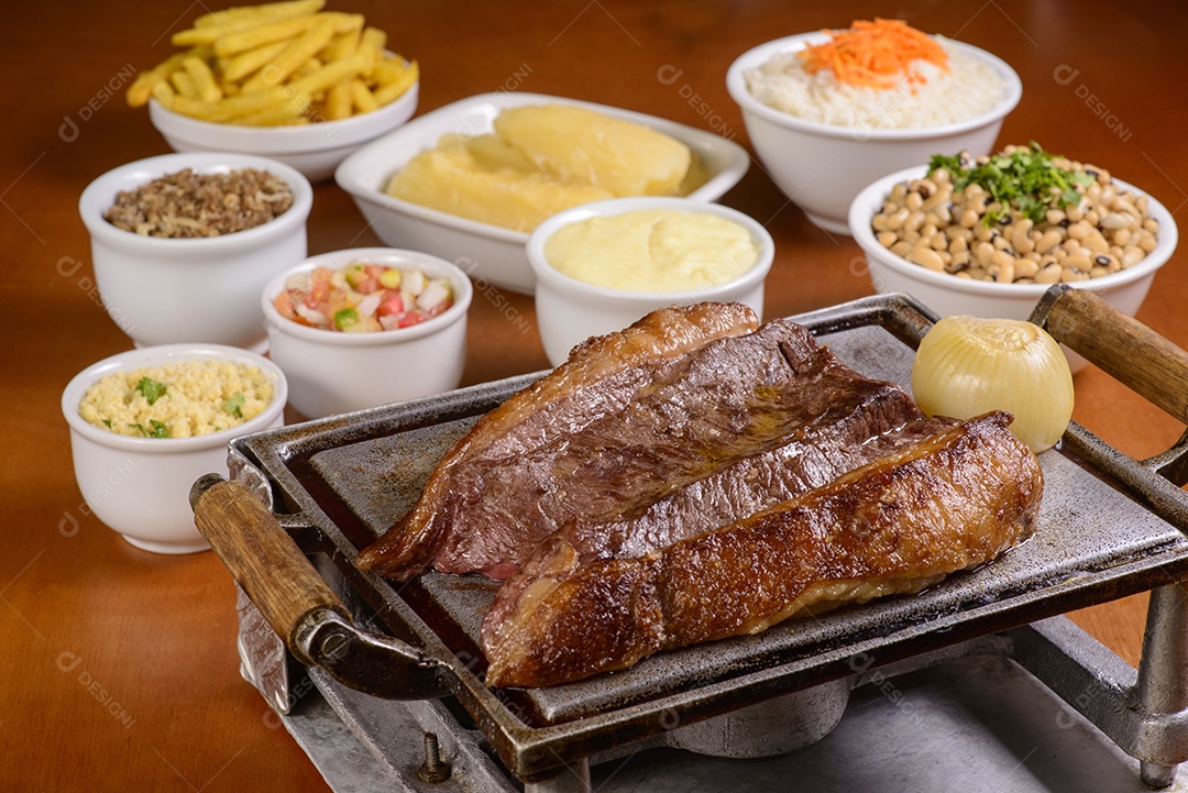 Picanha Brasileira. Bife de churrasco assado na grelha, servido com pratos tradicionais brasileiros.