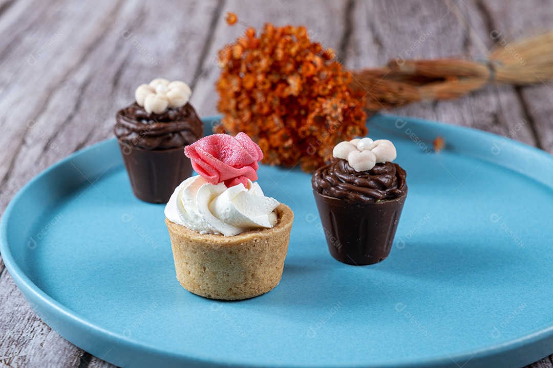 Pequenos doces sofisticados recheados com ganache de chocolate e cobertos com chantilly e fondant.