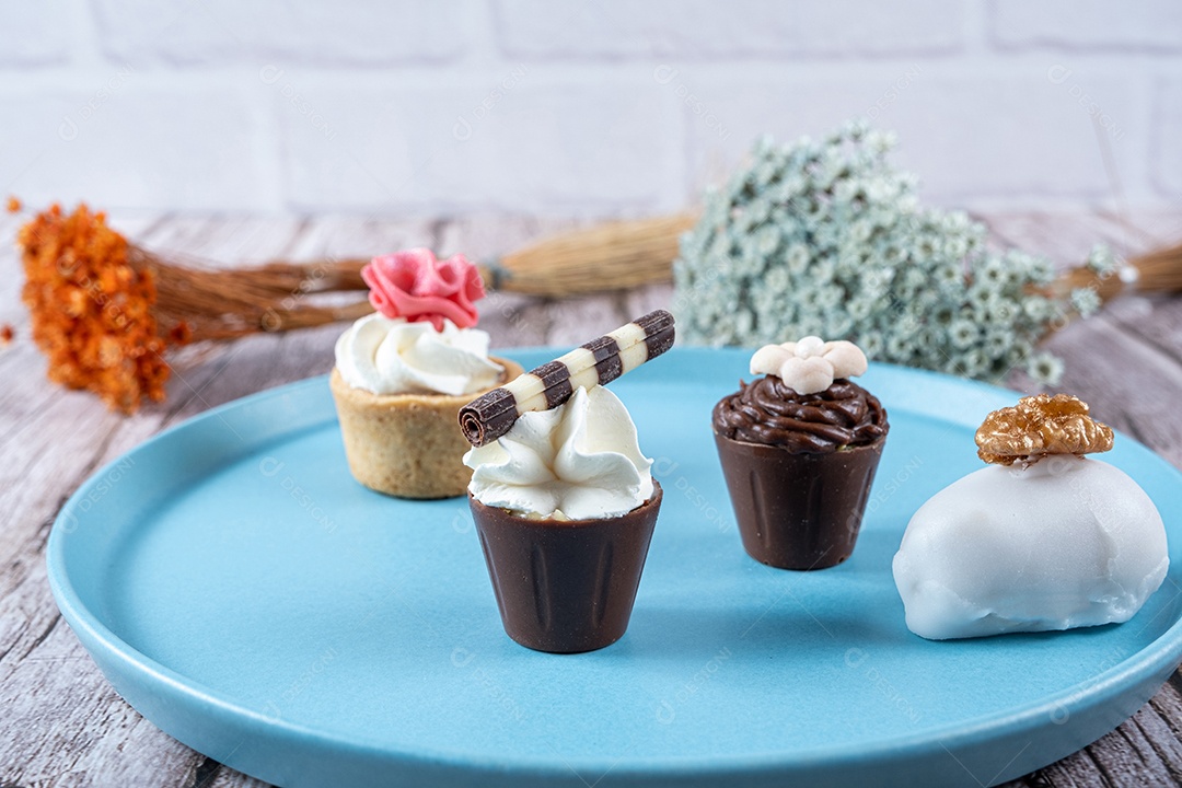 Closeup de quatro pequenos doces extravagantes cheios de ganache de chocolate e chantilly e fondant.