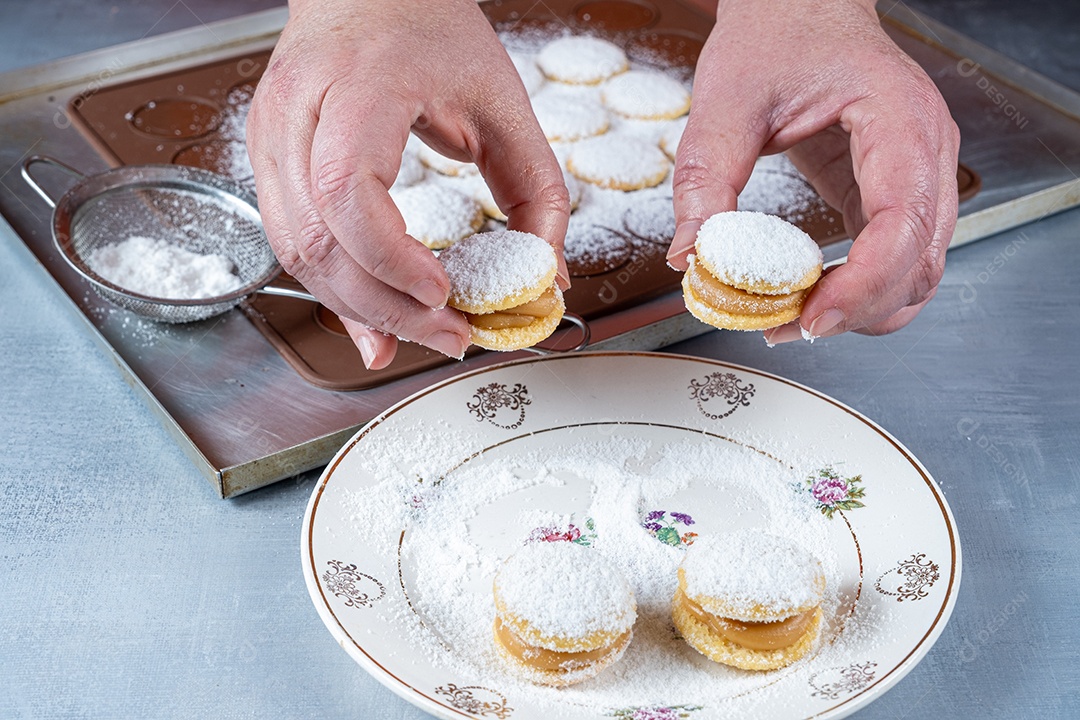 Confeiteiro levando um doce de casamento com açúcar polvilhado e recheio de doce de leite.