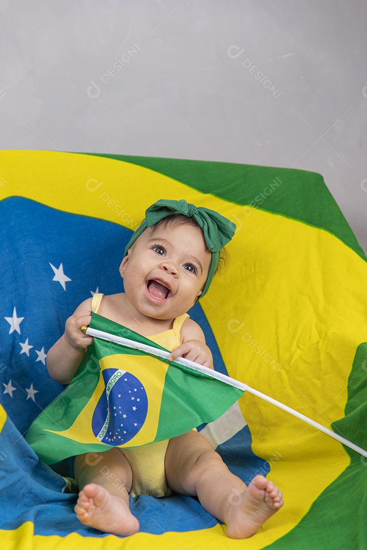 Linda criança bebe sentada sobre fundo bandeira brasil pais