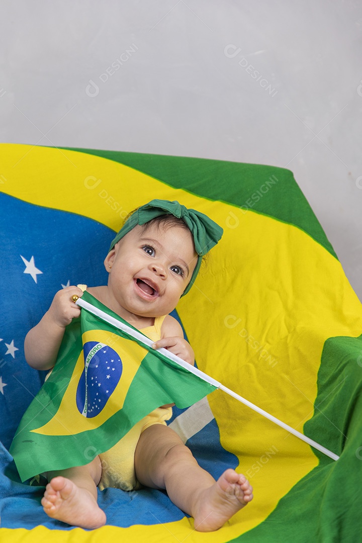 Linda criança bebe sentada sobre fundo bandeira brasil pais