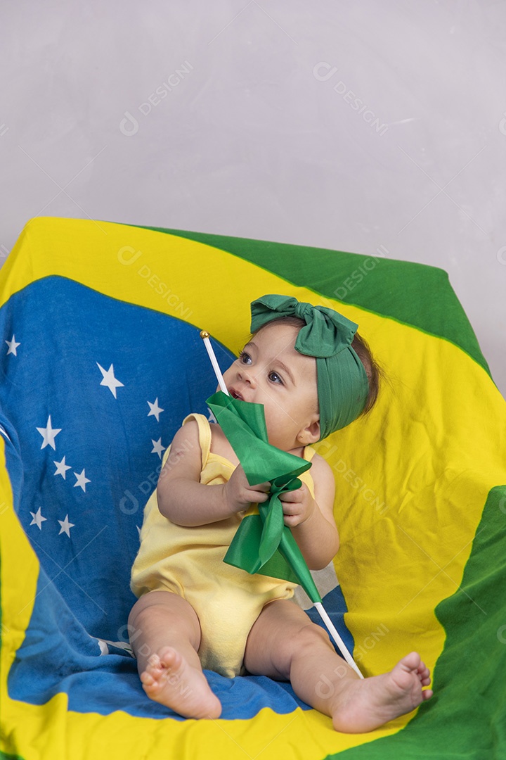 Linda criança bebe sentada sobre fundo bandeira brasil pais