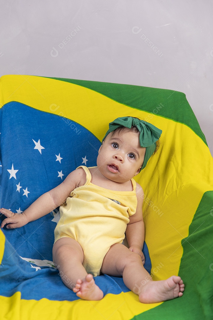 Linda criança bebe sentada sobre fundo bandeira brasil pais