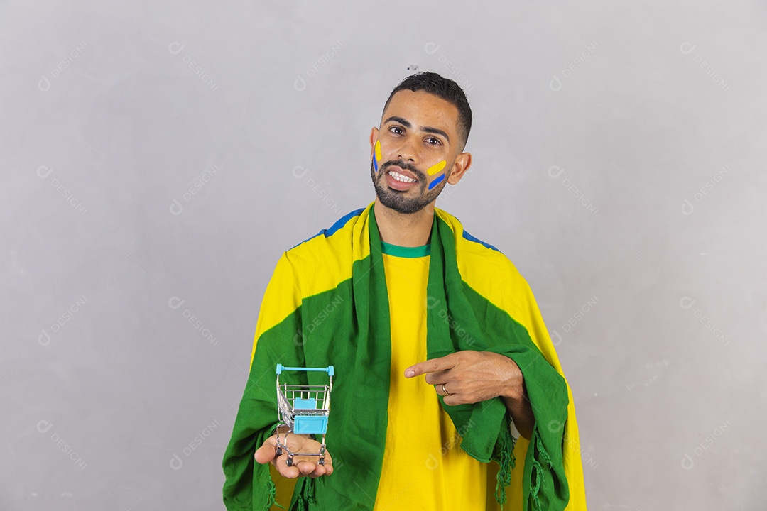 Homem jovem torcedor do brasil segurando carrinho de compras mercado