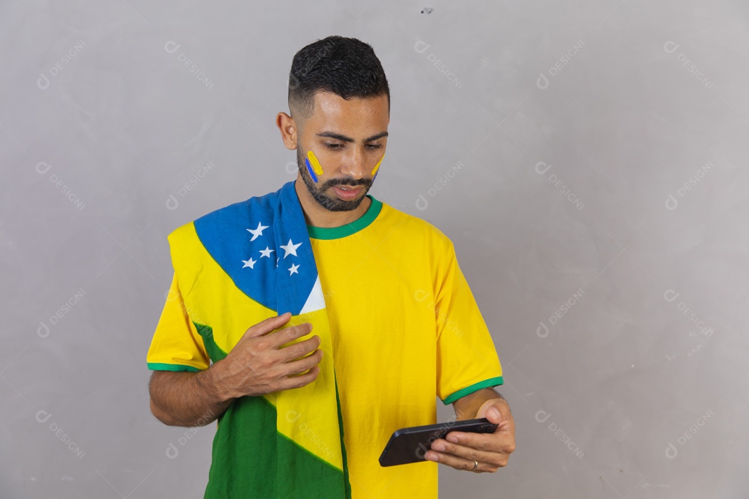 Homem brasileiro jovem torcedor do brasil segurando celular