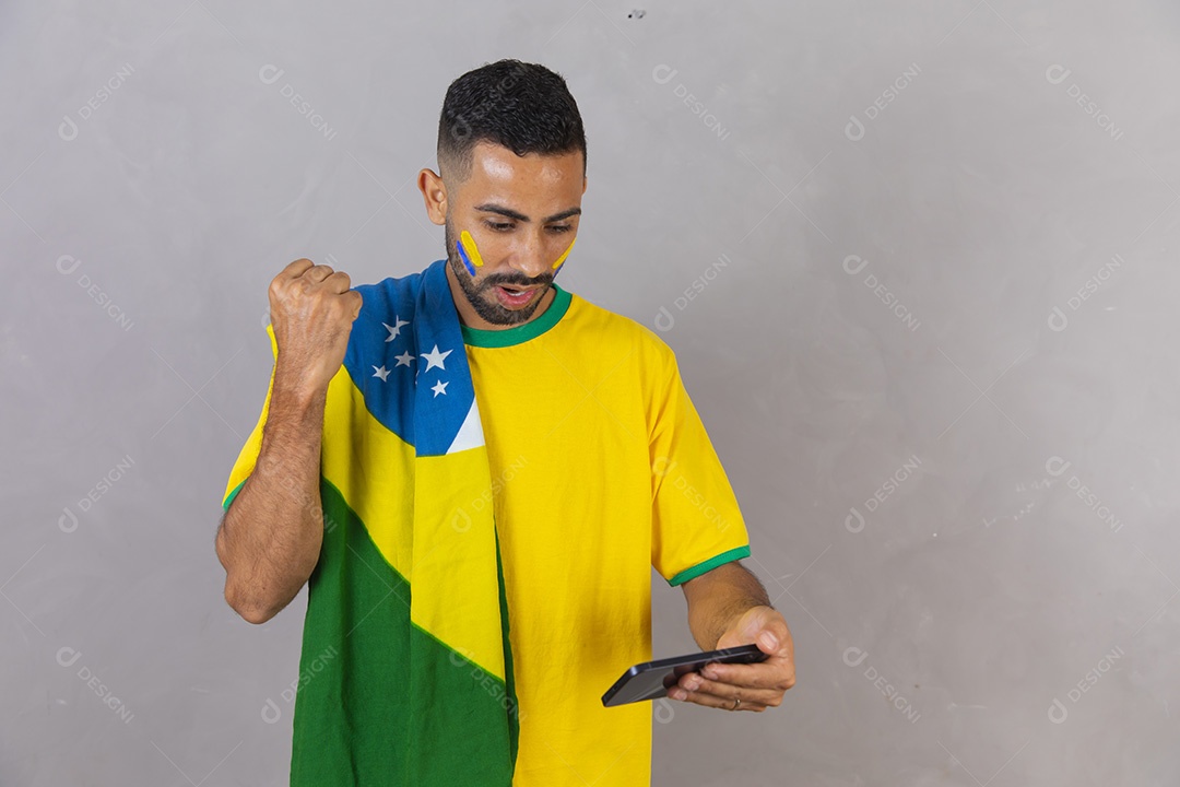 Homem brasileiro jovem torcedor do brasil usando celular