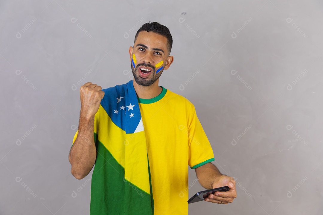Homem brasileiro jovem torcedor do brasil usando celular
