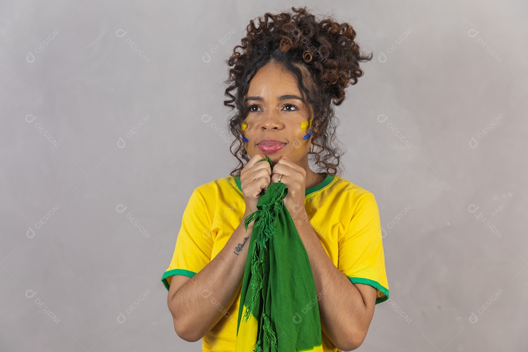 Linda mulher jovem morena segurando bandeira do brasil cabelo sobre fundo isolado amarelo