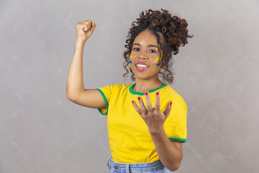Linda mulher jovem morena segurando bandeira do brasil cabelo sobre fundo isolado amarelo