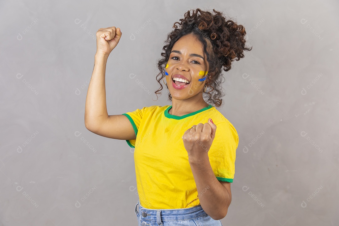 Linda mulher jovem morena segurando bandeira do brasil cabelo sobre fundo isolado amarelo