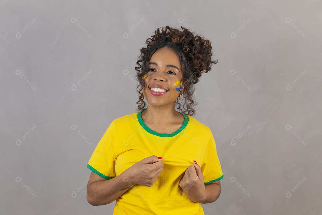 Linda mulher jovem morena segurando bandeira do brasil cabelo sobre fundo isolado amarelo