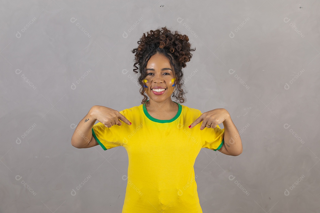 Linda mulher jovem morena segurando bandeira do brasil cabelo sobre fundo isolado amarelo