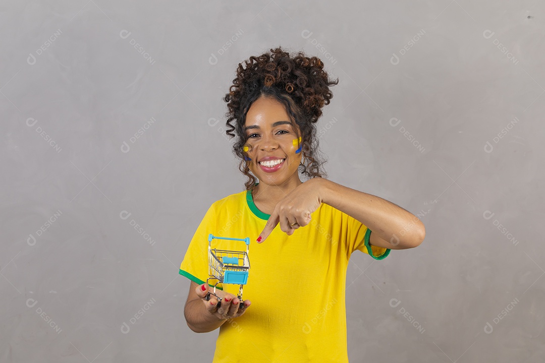 Linda mulher jovem morena segurando bandeira do brasil cabelo sobre fundo isolado amarelo