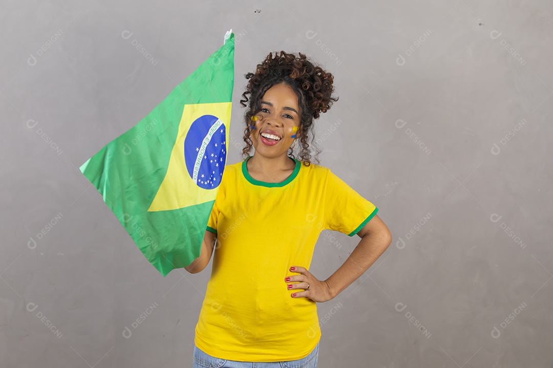 Linda mulher jovem morena segurando bandeira do brasil cabelo sobre fundo isolado amarelo