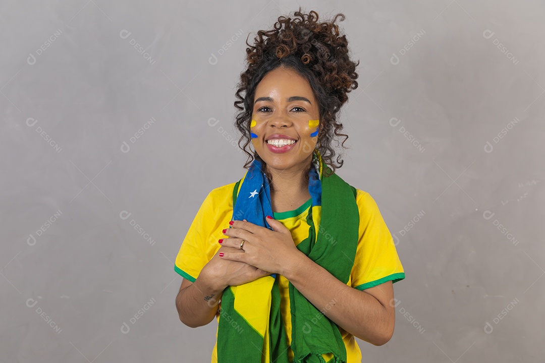 Linda mulher jovem morena segurando bandeira do brasil cabelo sobre fundo isolado amarelo