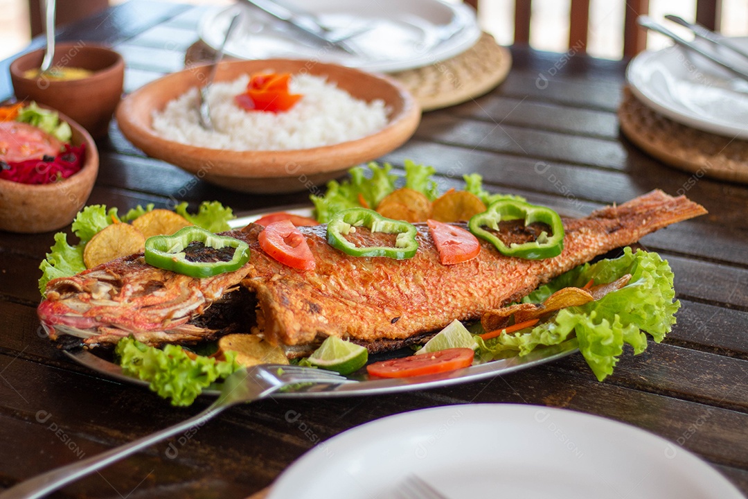 Peixe frito arroz sobre uma mesa de madeira comida restaurante