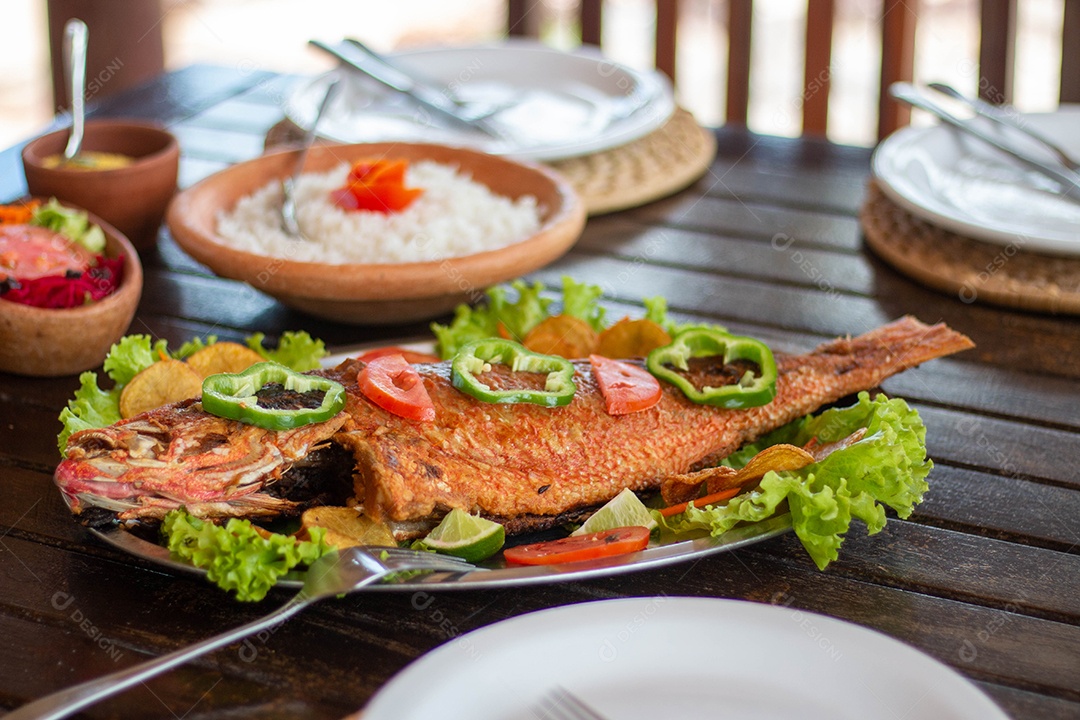Peixe frito arroz sobre uma mesa de madeira comida restaurante