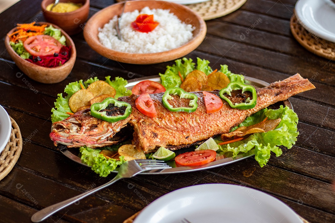 Peixe frito arroz sobre uma mesa de madeira comida restaurante