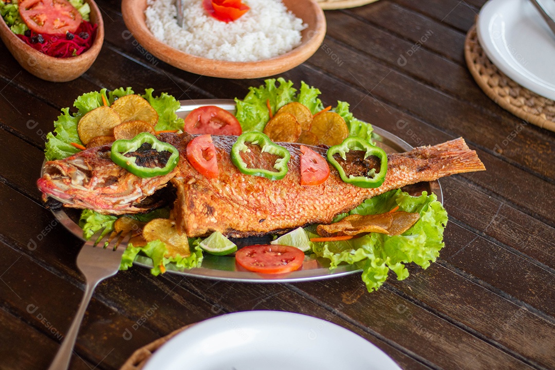 Peixe frito arroz sobre uma mesa de madeira comida restaurante