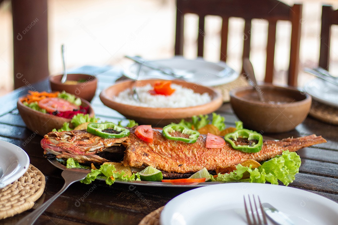 Peixe frito arroz sobre uma mesa de madeira comida restaurante