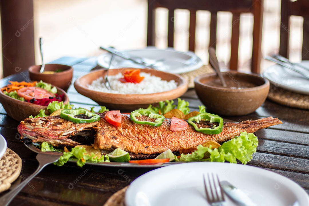 Peixe frito arroz sobre uma mesa de madeira comida restaurante