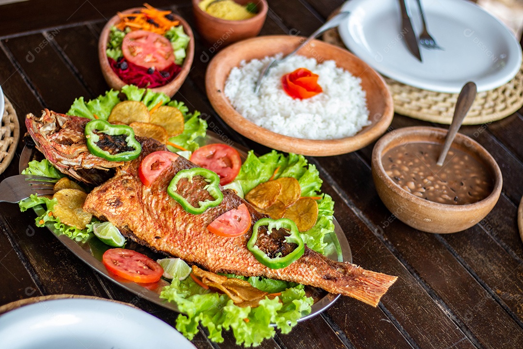 Peixe frito arroz sobre uma mesa de madeira comida restaurante