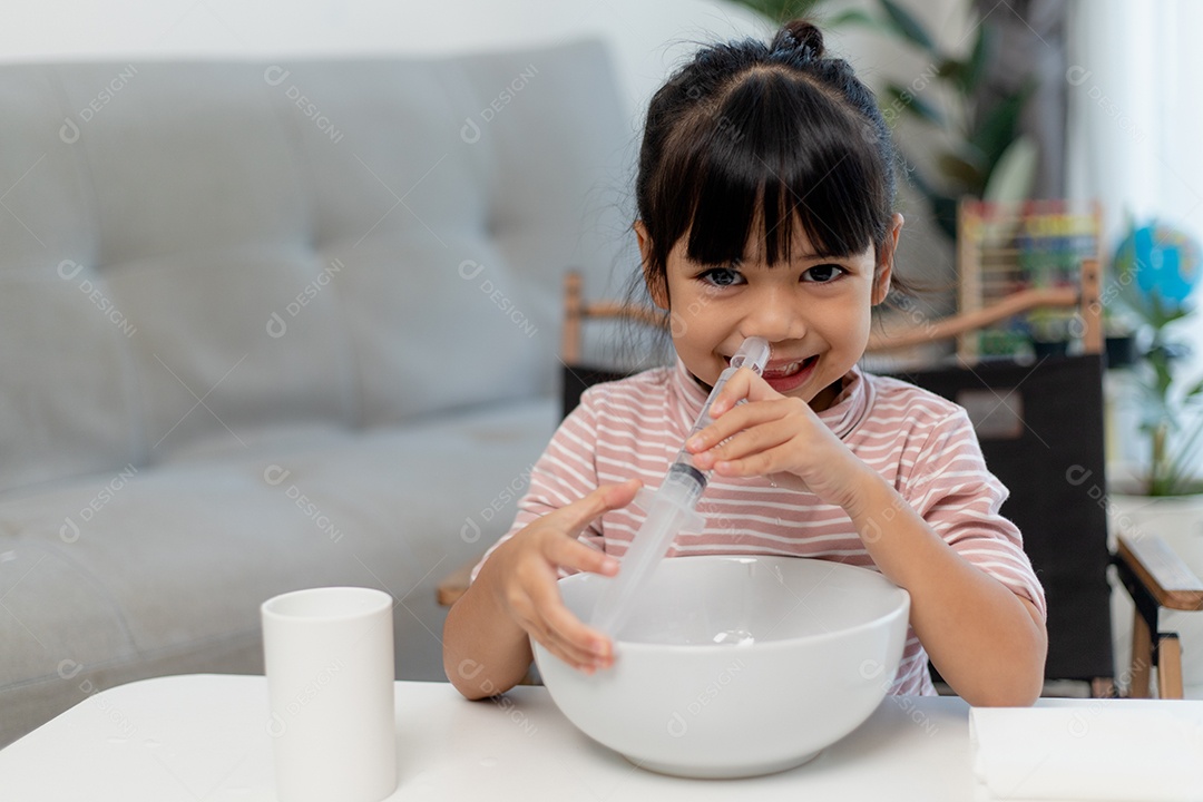 Menina asiática fazendo  lavagem nasal salina menina asiática em casa.