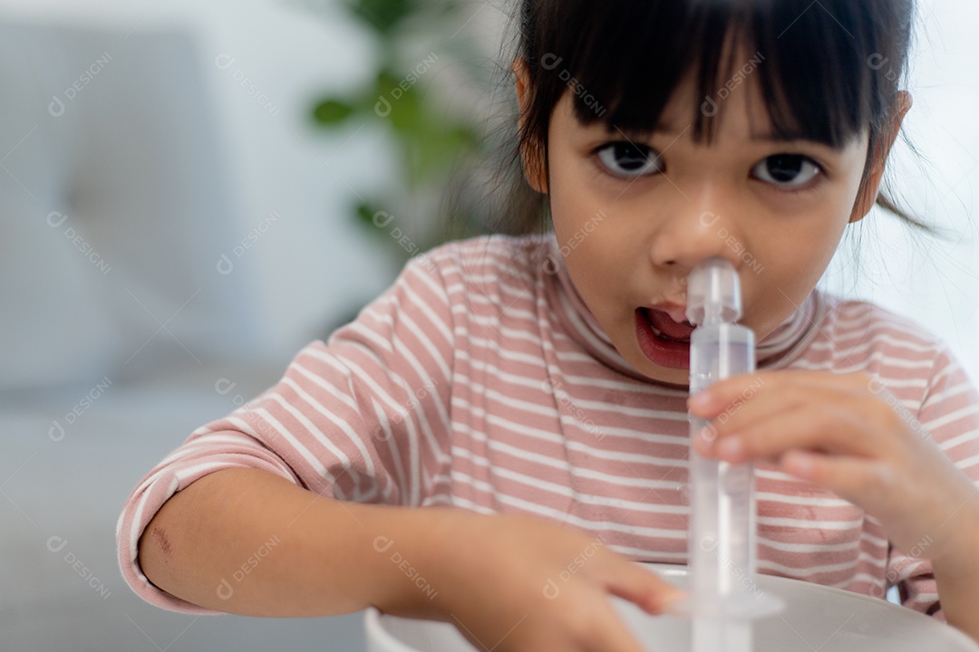 Menina asiática fazendo  lavagem nasal salina menina asiática em casa.