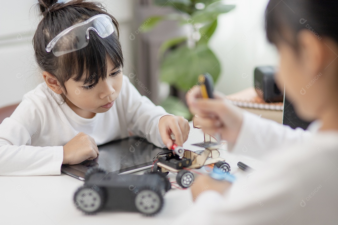 Dois estudantes asiáticos aprendem a codificar carros robóticos e cabos de placa eletrônica em STEM, STEAM, código de computador de tecnologia de ciência de engenharia matemática em robótica para conceitos de crianças.