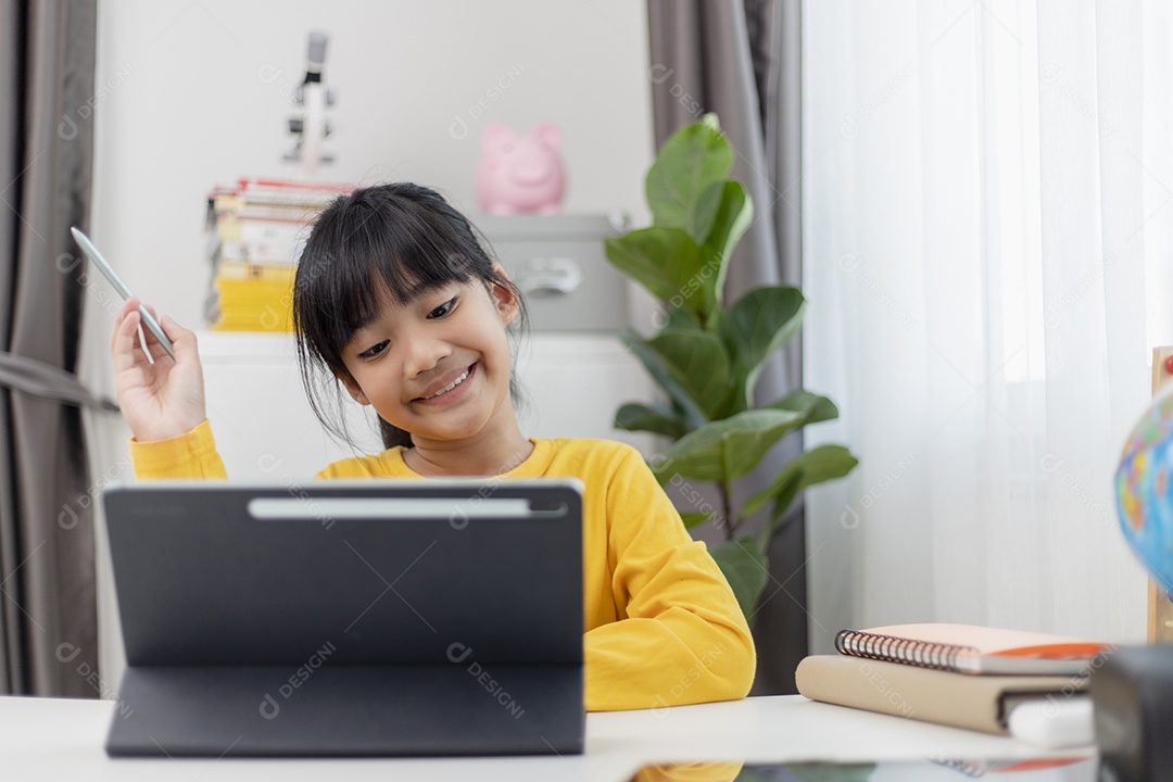 Menina asiática tendo aula on-line e feliz pelo conceito de pandemia de coranavírus de quarentena escolar em casa